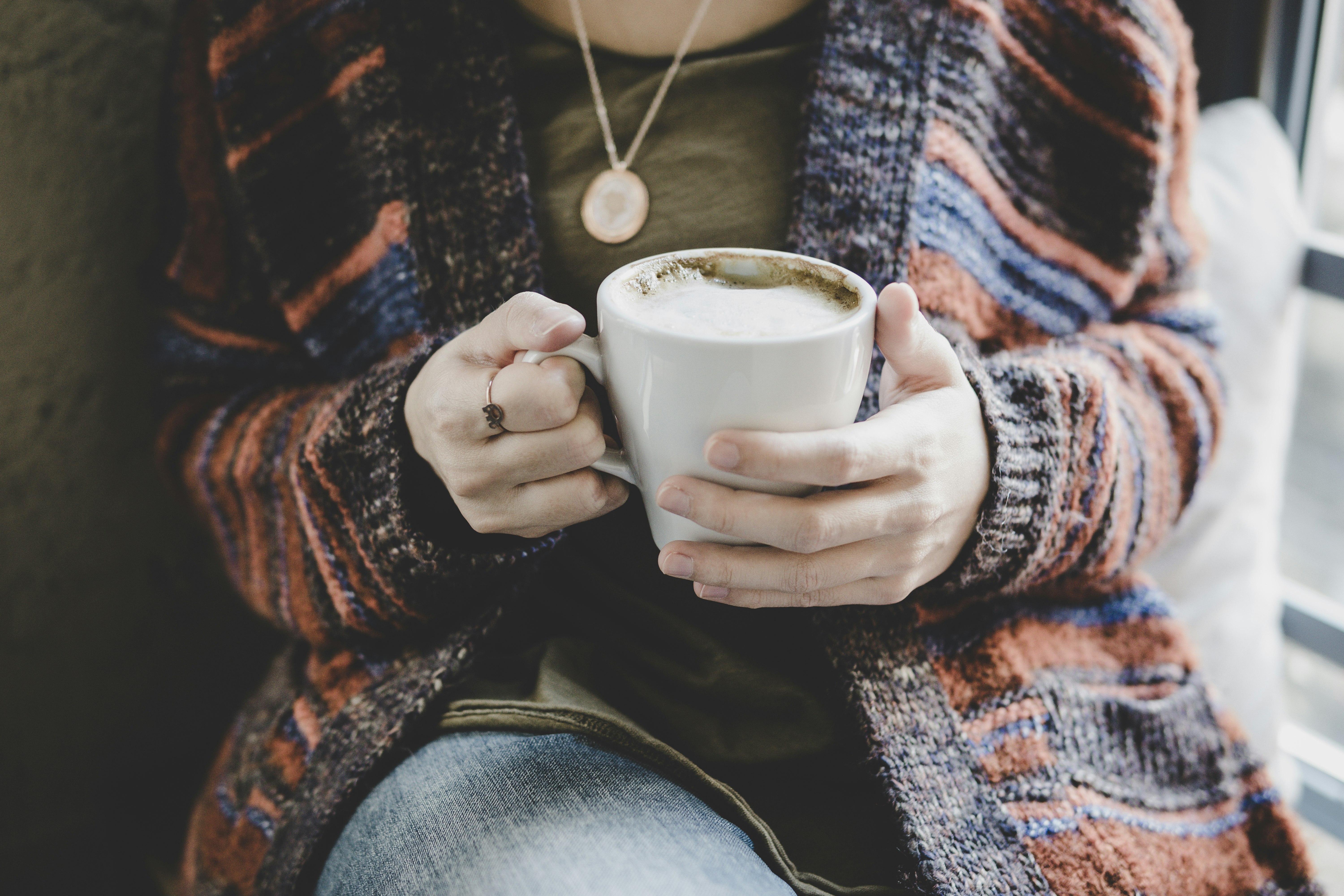 person holding white ceramic cup